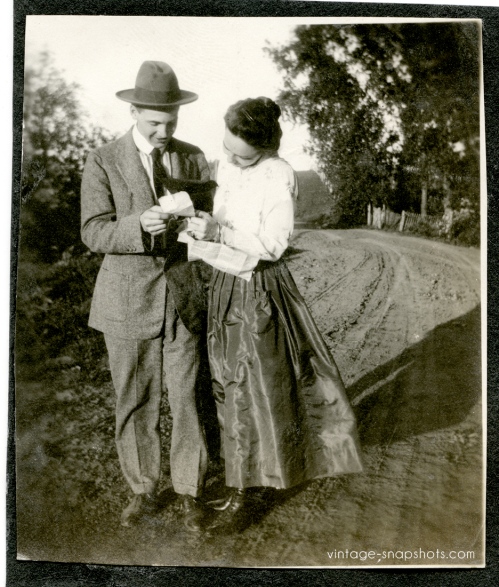 Circa 1911 vintage snapshot of a couple reading what may be a letter